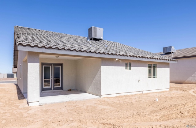 rear view of property featuring french doors, a patio, and central AC