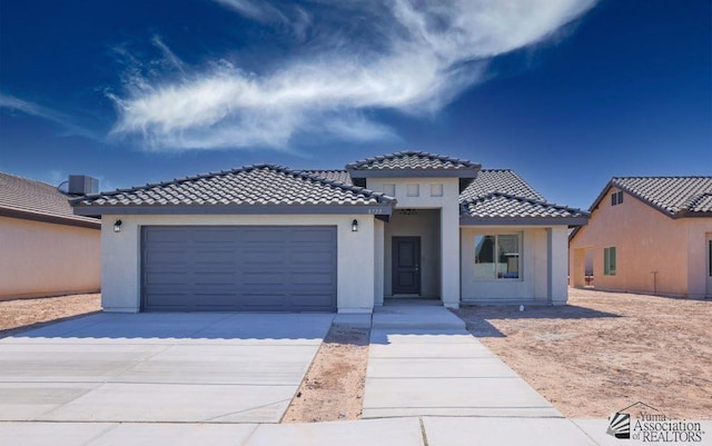 view of front of house with a garage and central AC