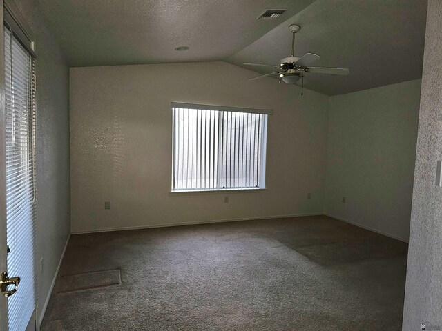 spare room featuring a textured ceiling, ceiling fan, carpet, and vaulted ceiling