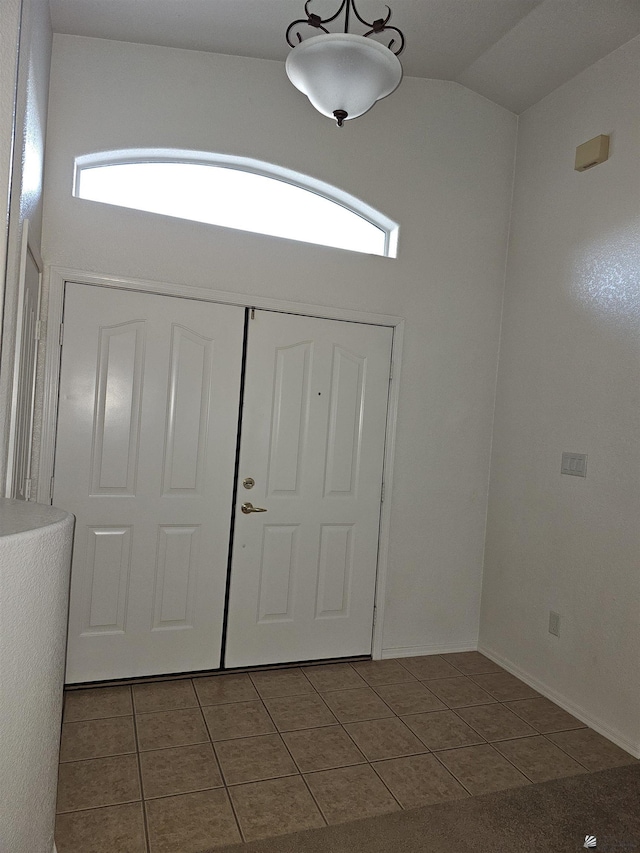 tiled foyer featuring vaulted ceiling