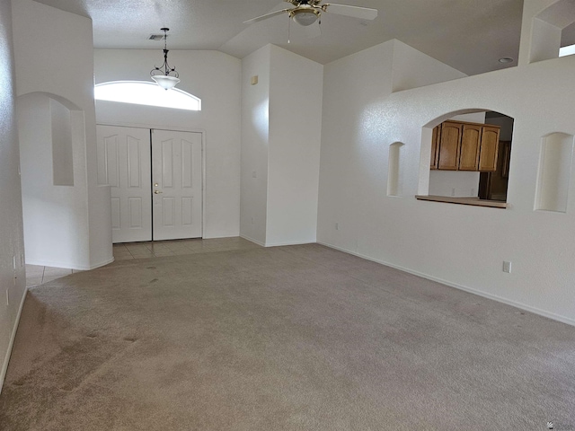 carpeted foyer featuring ceiling fan and high vaulted ceiling