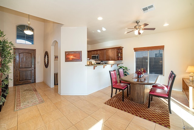 tiled dining area with ceiling fan and a healthy amount of sunlight