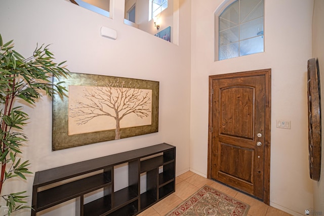 tiled entryway with a wealth of natural light and a high ceiling