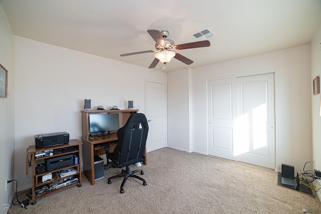 carpeted home office featuring ceiling fan