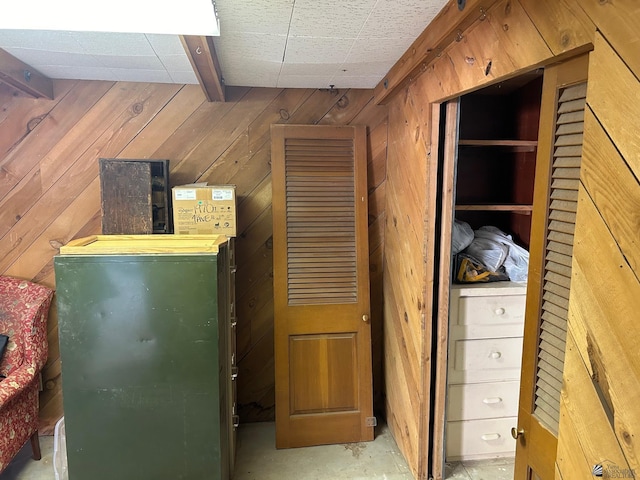 interior space with beam ceiling and wood walls