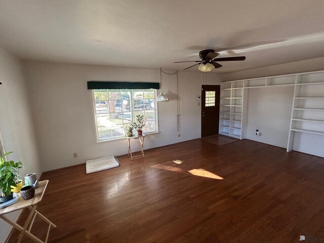 unfurnished living room featuring ceiling fan and dark hardwood / wood-style flooring