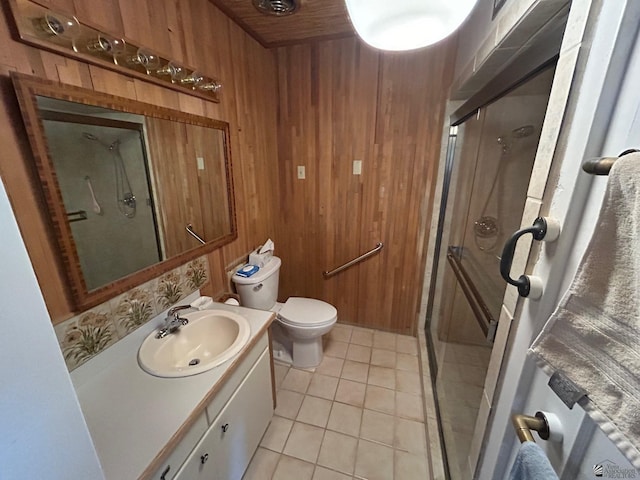 bathroom featuring wood walls, a shower with door, vanity, and tile patterned flooring