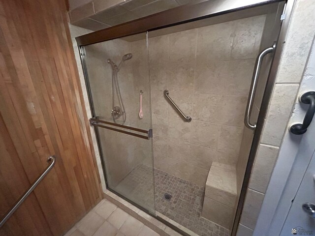 bathroom featuring walk in shower and wooden walls