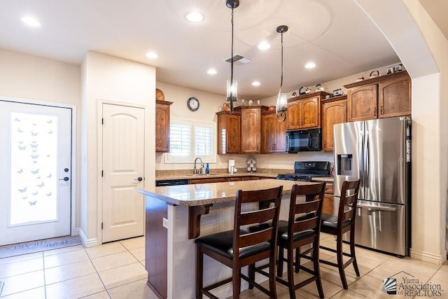 kitchen with a center island, black appliances, sink, decorative light fixtures, and light tile patterned flooring