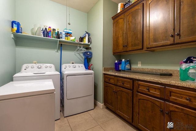 washroom featuring cabinets, light tile patterned floors, and separate washer and dryer