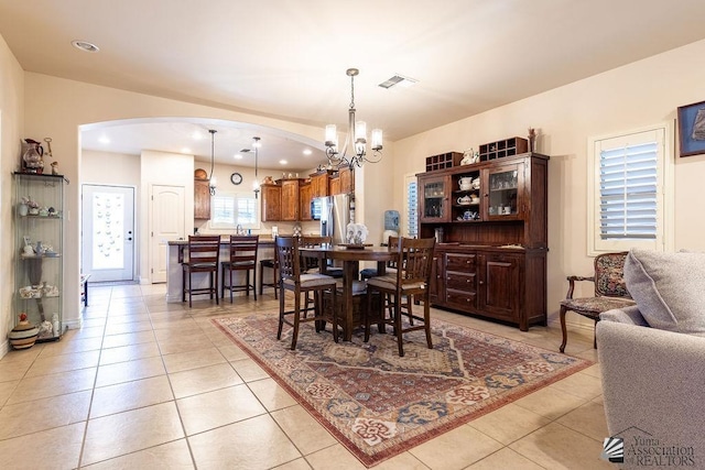 dining area featuring light tile patterned flooring and an inviting chandelier