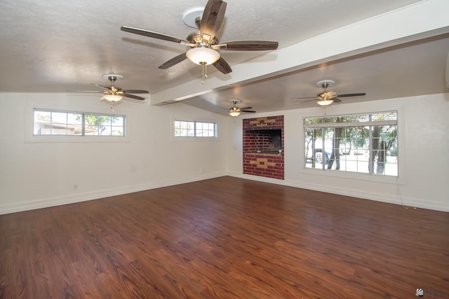 unfurnished living room featuring vaulted ceiling with beams, a textured ceiling, baseboards, and dark wood-type flooring