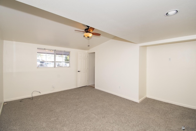 carpeted spare room with lofted ceiling, a ceiling fan, and baseboards