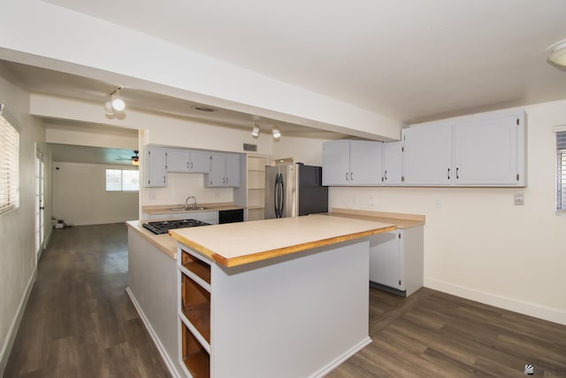 kitchen with a kitchen island, freestanding refrigerator, light countertops, a sink, and black gas stovetop