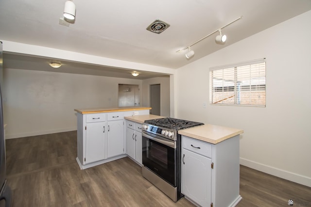 kitchen featuring white cabinets, lofted ceiling, gas range, a peninsula, and light countertops