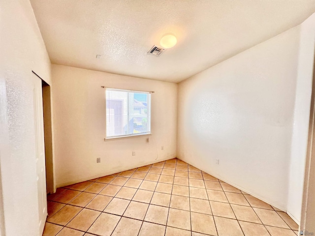 unfurnished bedroom featuring light tile patterned floors and a textured ceiling