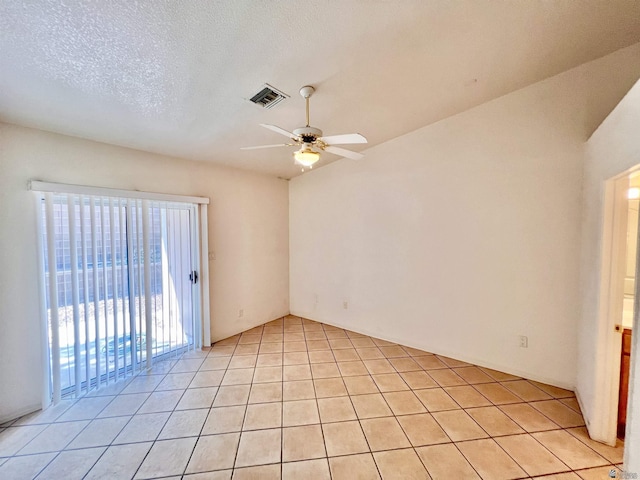 spare room featuring light tile patterned floors, a textured ceiling, and ceiling fan