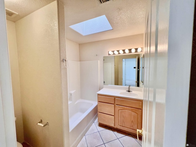 full bathroom with vanity, tile patterned floors, a skylight, a textured ceiling, and shower / bath combination