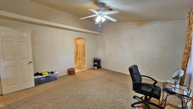 unfurnished office featuring visible vents, baseboards, ceiling fan, carpet floors, and arched walkways