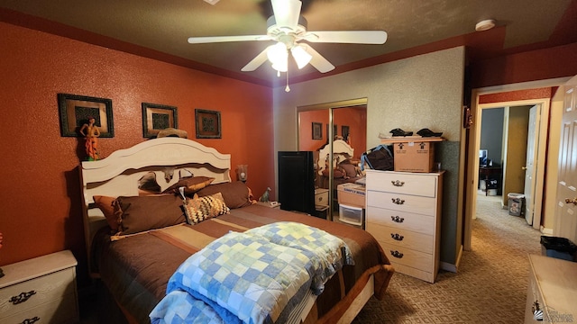 bedroom with carpet, a closet, a textured wall, and ceiling fan