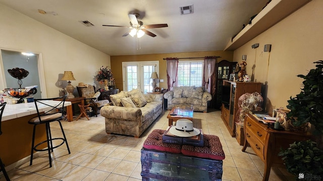 living area featuring light tile patterned floors, visible vents, french doors, and vaulted ceiling