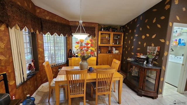 dining area with washer and dryer, light tile patterned floors, and wallpapered walls