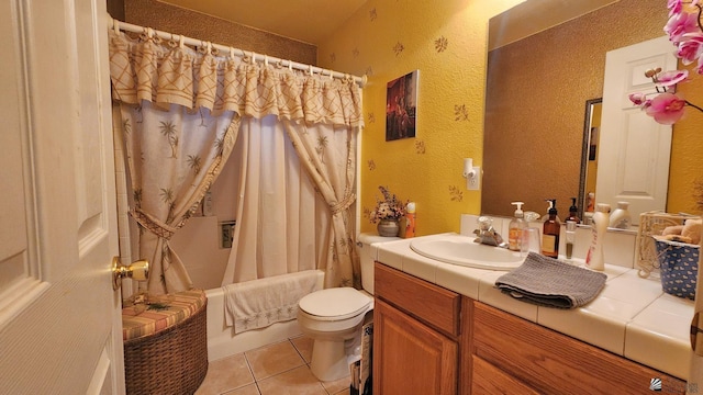 full bathroom with tile patterned floors, toilet, shower / bath combo, vanity, and a textured wall