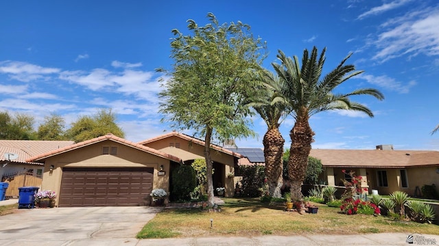 ranch-style home featuring stucco siding, an attached garage, driveway, and solar panels