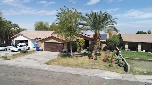 ranch-style house featuring solar panels, a tiled roof, stucco siding, a garage, and driveway