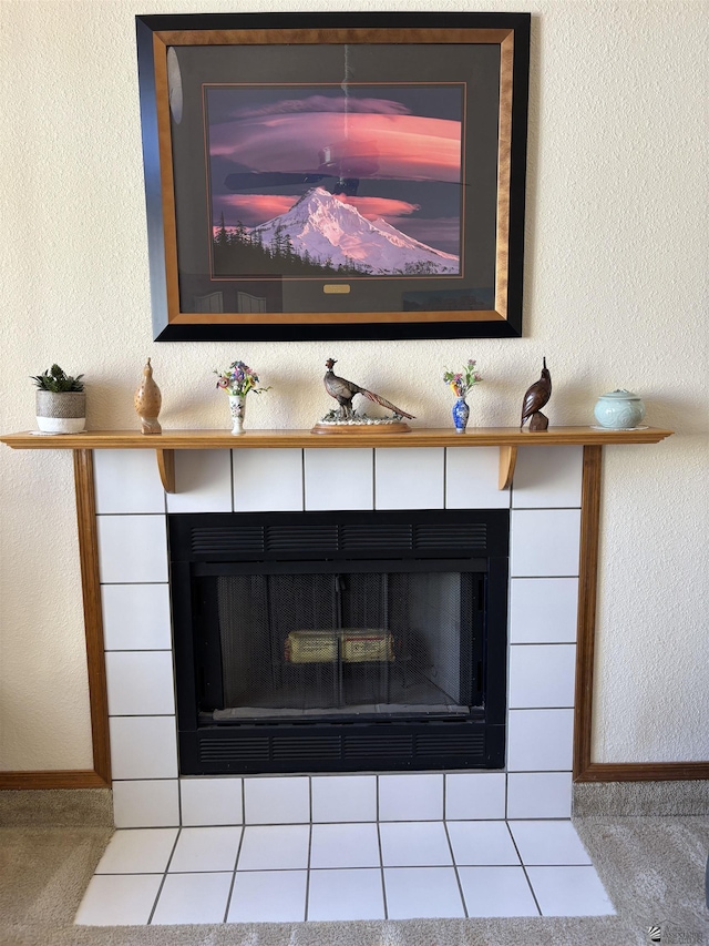 carpeted living room with a tile fireplace