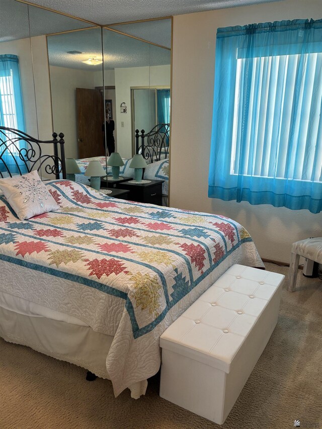 bedroom featuring a textured ceiling and carpet floors