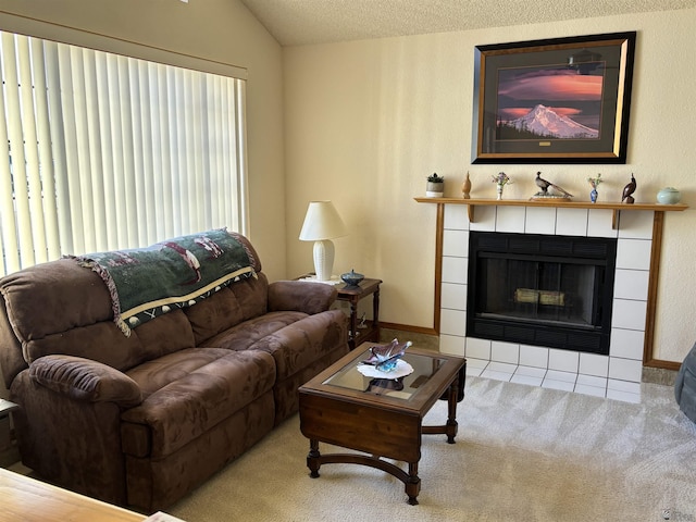 carpeted living room with a tiled fireplace, a textured ceiling, and lofted ceiling