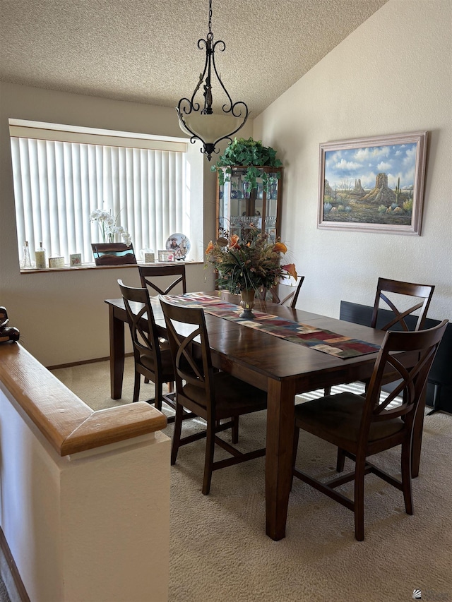 carpeted dining area with a textured ceiling and lofted ceiling