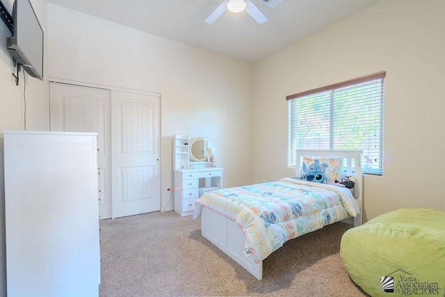 bedroom with a closet, a ceiling fan, and light colored carpet