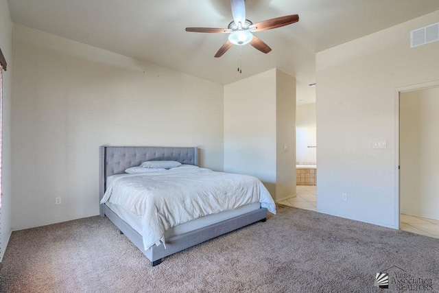 carpeted bedroom with connected bathroom, tile patterned flooring, visible vents, and ceiling fan