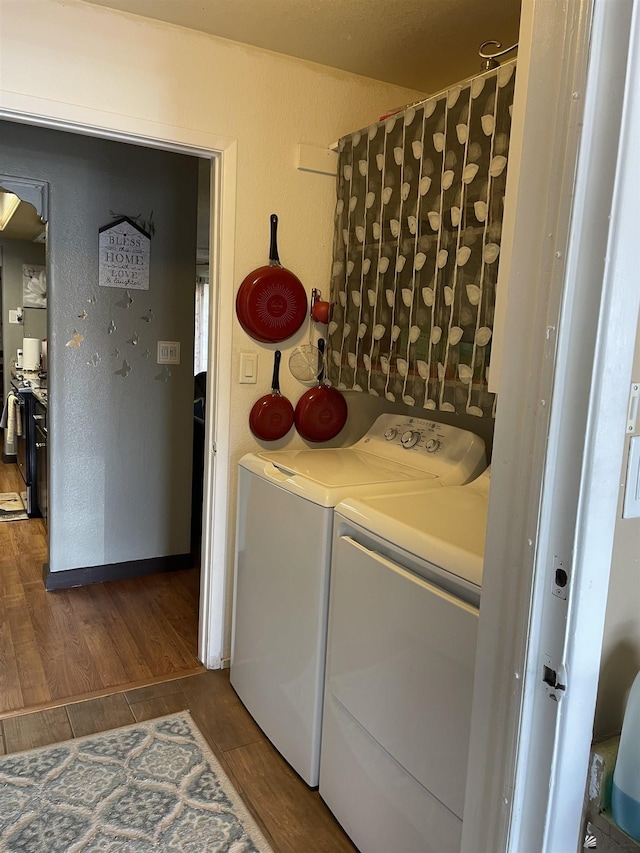 clothes washing area with separate washer and dryer and dark hardwood / wood-style flooring