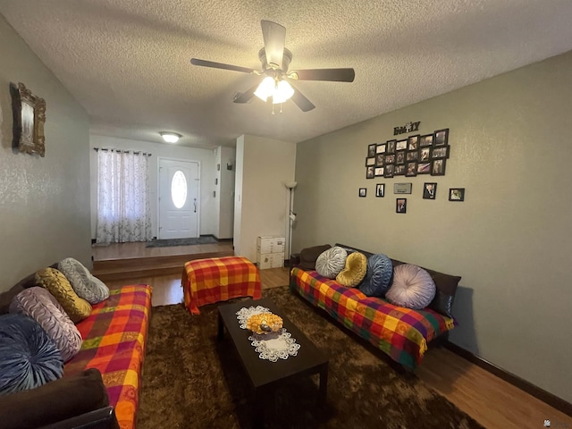 living room featuring ceiling fan, hardwood / wood-style floors, and a textured ceiling