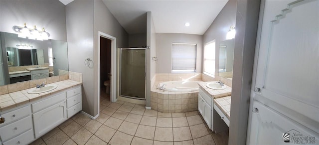 bathroom featuring a garden tub, two vanities, a sink, and a shower stall