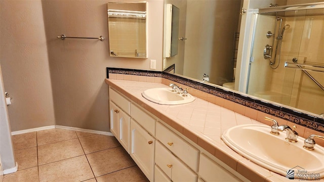 full bath with a stall shower, tile patterned flooring, and a sink