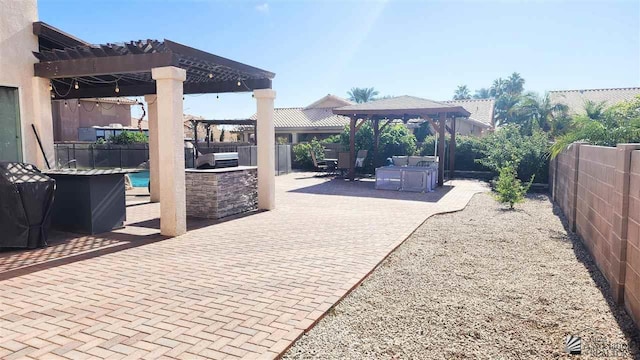 view of patio featuring a gazebo, a fenced backyard, an outdoor kitchen, and a pergola