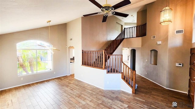 foyer featuring baseboards, ceiling fan, stairway, and wood finished floors