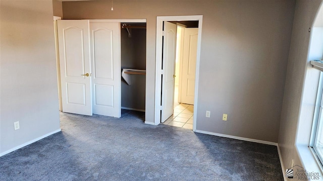 unfurnished bedroom featuring carpet floors, a closet, and baseboards