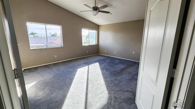 unfurnished room with dark colored carpet, vaulted ceiling, baseboards, and ceiling fan