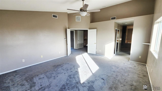 unfurnished bedroom featuring high vaulted ceiling, carpet, and visible vents