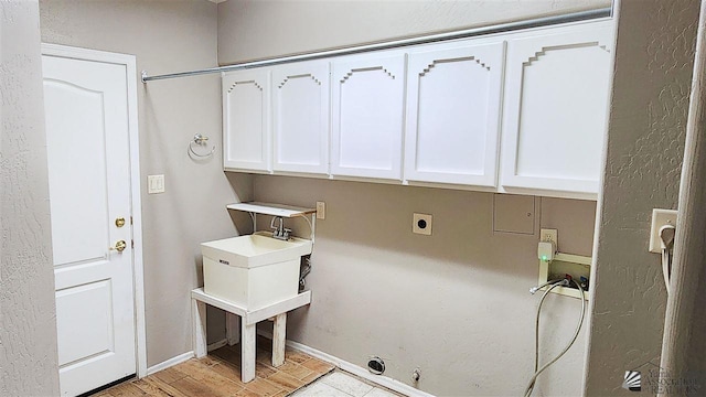 laundry room with gas dryer hookup, hookup for an electric dryer, washer hookup, baseboards, and cabinet space