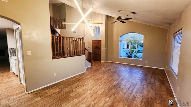 unfurnished living room with stairway, ceiling fan, visible vents, and wood finished floors