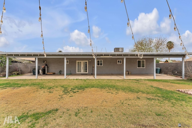 back of house with a patio, a lawn, a fenced backyard, and stucco siding