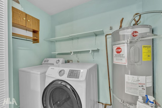 laundry area with strapped water heater, washer and clothes dryer, and laundry area