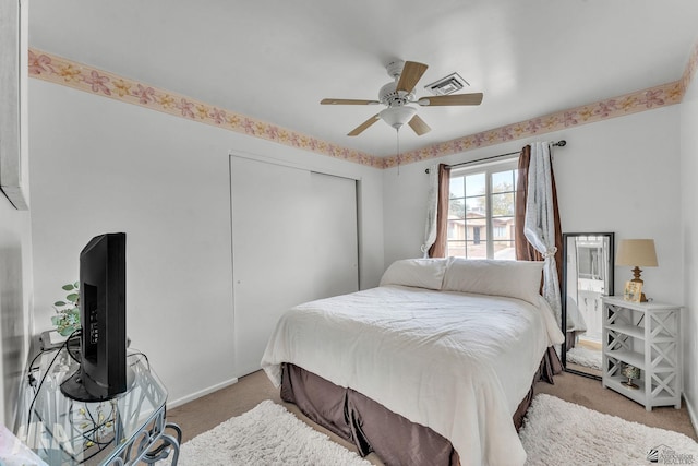 bedroom with a ceiling fan, visible vents, a closet, and light colored carpet