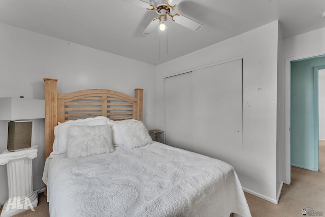 bedroom featuring ceiling fan, baseboards, a closet, and light colored carpet